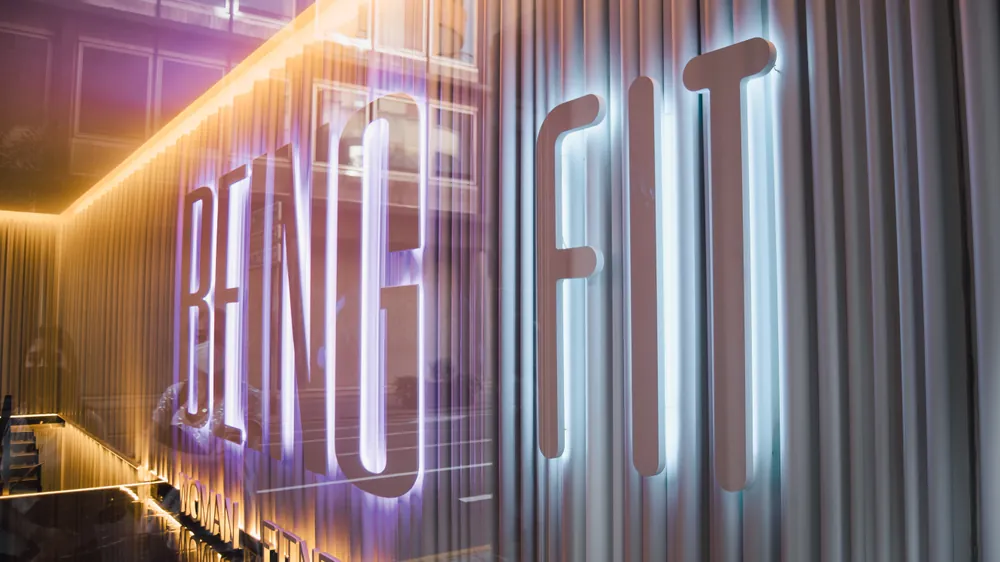 Rótulo iluminado de Being Fit en la entrada del estudio