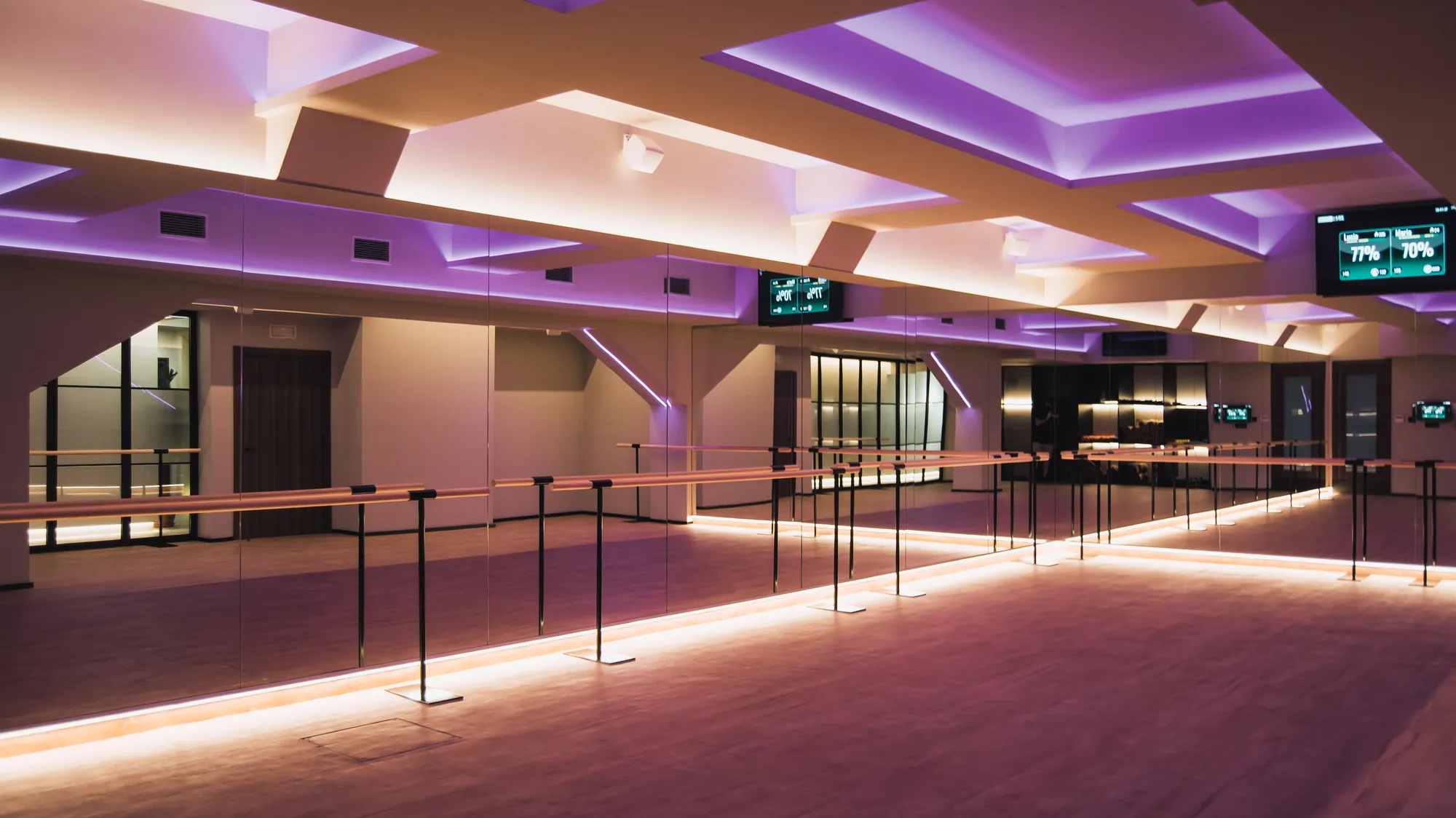 Sala de Being Fit con barras de ballet, espejos y luz violeta